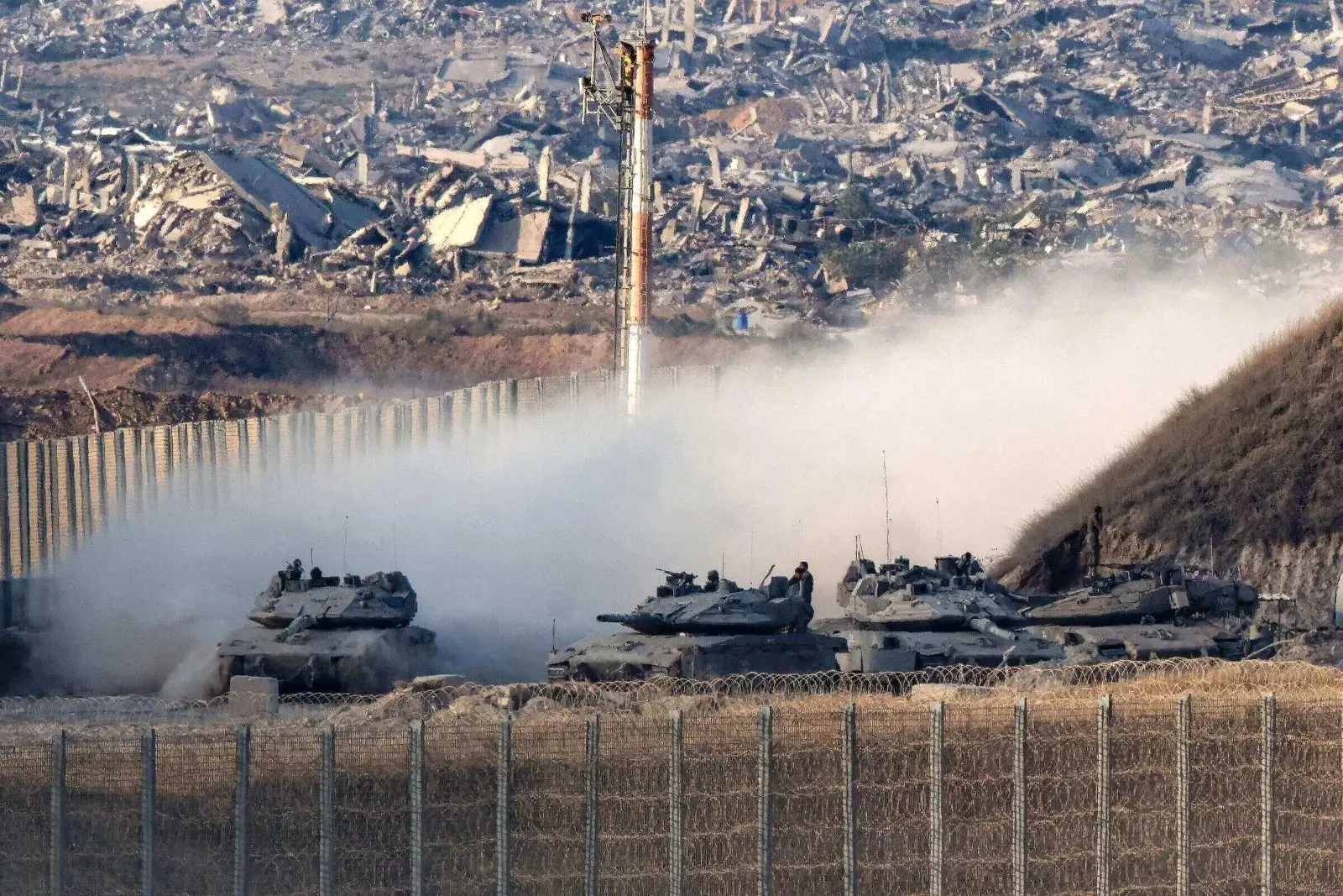 Tanks moving through a dusty landscape.