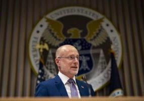 Man speaking at podium with US government seal